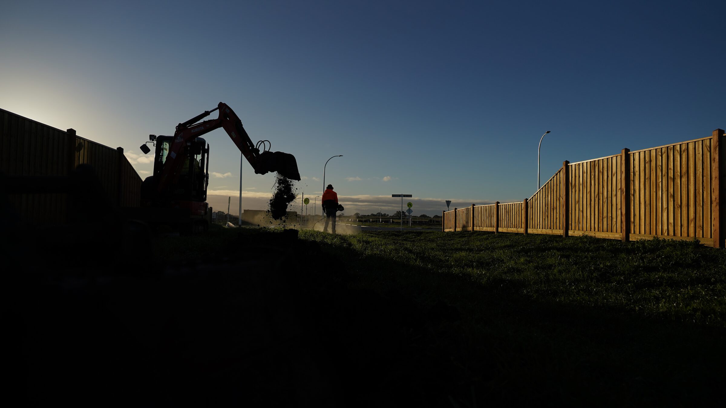 Tree planting work on a commercial landscape site at sunset